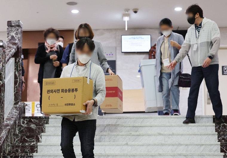 제8회 전국동시지방선거 사전투표 이틀째인 28일 서울 용산구의회에 마련된 사전투표소에서 관계자들이 관내 투표함과 관외사전 회송용봉투를 옮기고 있다. 연합