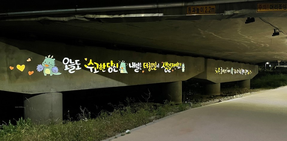 용인시 마북천 삼거교 하부 벽면에 로고젝터를 설치한 모습. 사진=용인시 마북동