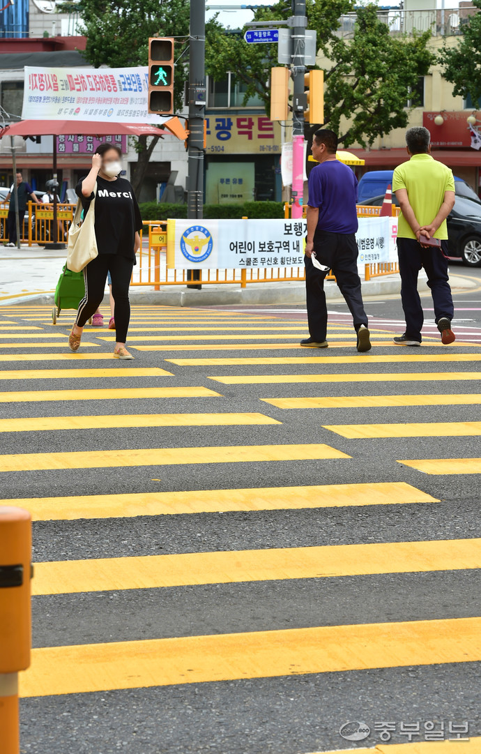 지난해 교통사고가 잇따라 발생한 인천 중구 신광초등학교앞 어린이보호구역에 15일 노란색 횡단보도가 설치돼 시민들이 길을 건너고 있다. 정선식기자