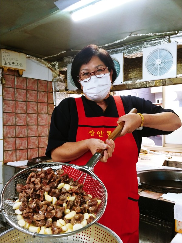 경옥삼(64) 장안통닭 대표가 통닭 서비스에 들어가는 닭모래집과 통마늘을 튀겨 보이고 있다.