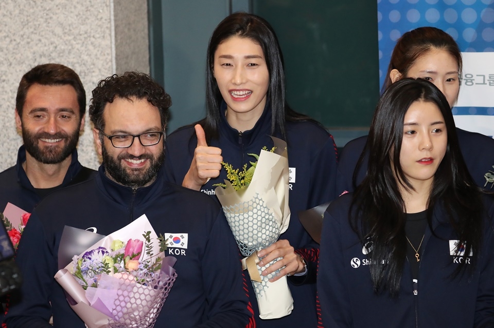 2020 도쿄 올림픽 아시아지역예선 결승에서 태국을 꺾고 도쿄올림픽행 티켓을 거머쥔 한국 여자배구 대표팀 주장 김연경(가운데)과 스테파노 라바리니 감독(왼쪽 두번째)이 13일 인천국제공항을 통해 귀국, 환영 행사에서 미소를 짓고 있다. 연합