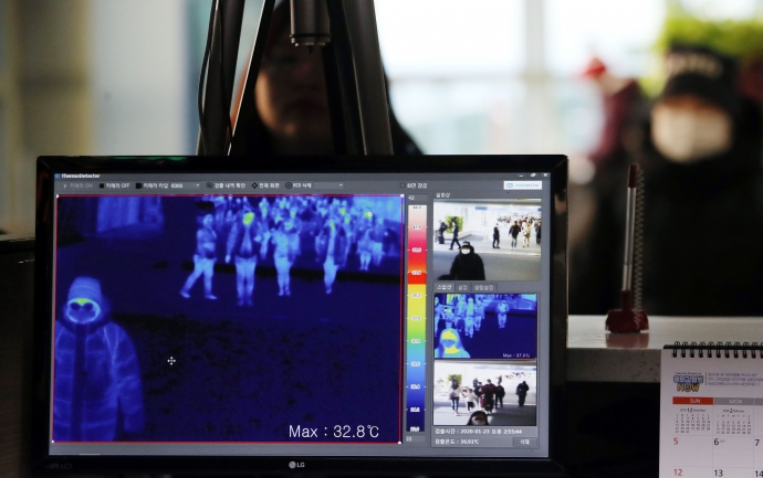 질병관리본부 국립검역소 직원들이 23일 인천국제공항 1터미널 입국장에서 열화상 카메라로 승객들의 체온을 측정하고 있다. 사진=연합