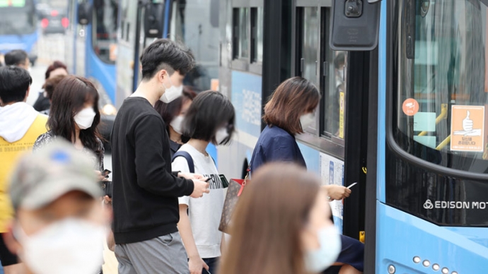 버스정류장에서 마스크를 착용한 시민들이 버스를 이용하고 있다. 사진=연합