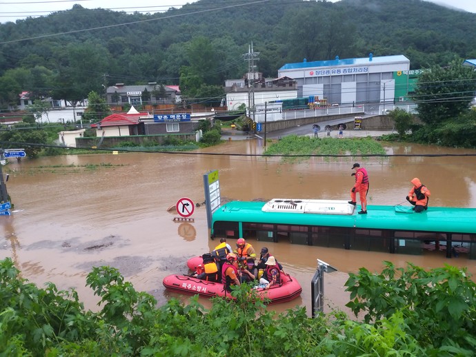 6일 오전 파주시의 한 도로에서 시내버스가 물에 잠겨 구조 대원들이 승객들을 구조하고 있다. 사진=파주소방서