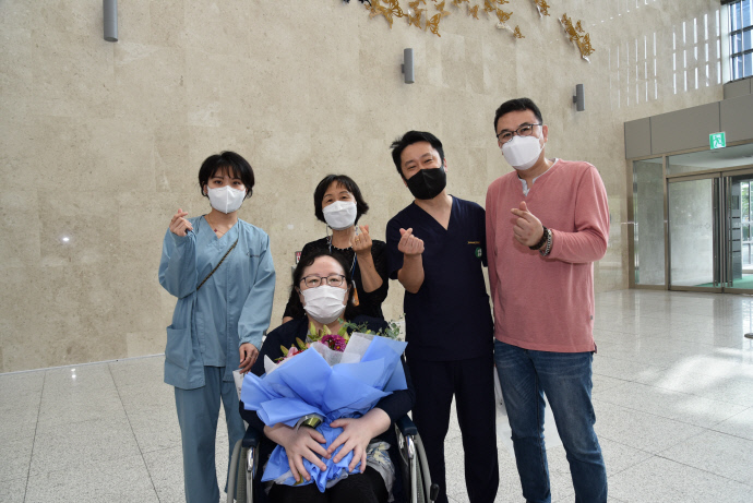 퇴원하는 이씨(중앙)와 성남시의료원 직원들이 기념촬영을 하고 있다.|성남시의료원 제공