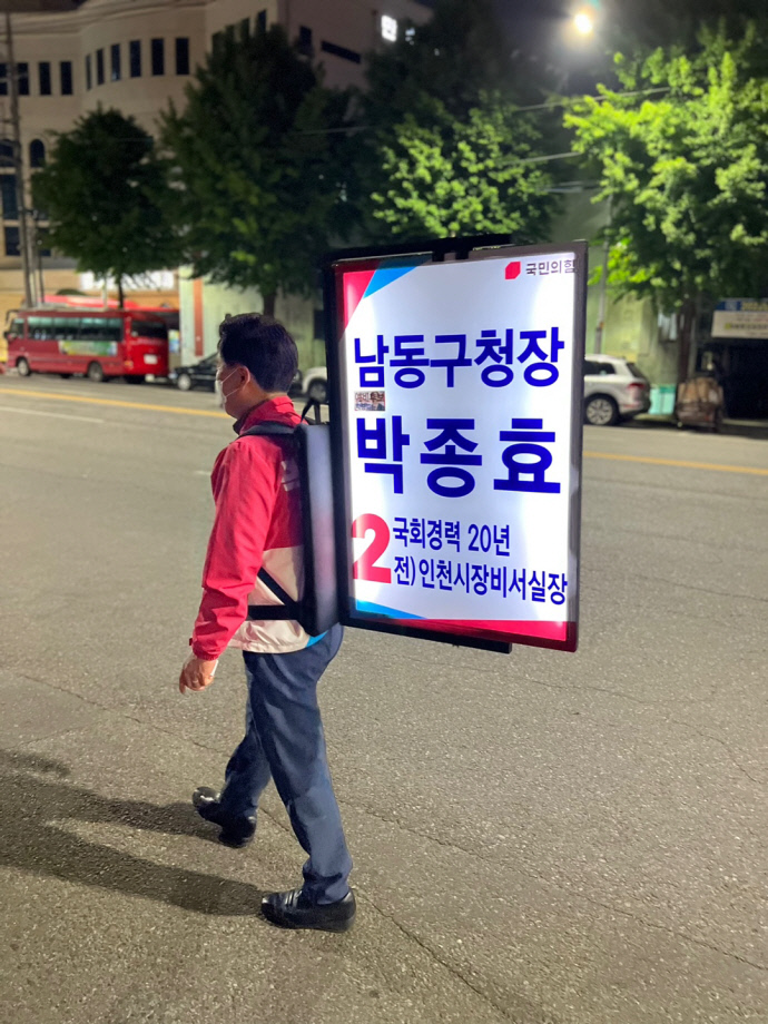 박종효 인천남동구청장 후보가 해가 지자 자신을 알리는 LED판넬을 등에 지고 길을 나서고 있다. 사진=박종효 후보