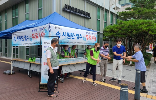 용인 신갈동 주민단체 위원들이 주민에게 생수를 나눠주고 있다. 사진=용인시청
