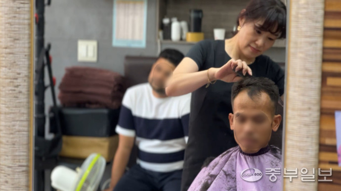 지난달 23일 포천 송우리 버스 터미널 인근의 한 미용실. 미용사가 이주민 손님의 머리카락을 자르고 있다. 김도윤기자 