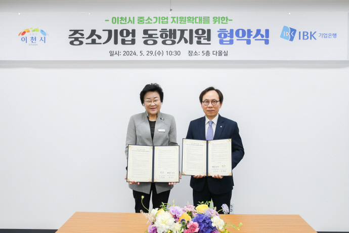 김경희 이천시장(왼쪽)과 최광진 IBK기업은행 부행장이 이천시 관내 중소기업의 자금난 해소를 위한 ‘중소기업 동행지원’ 업무협약을 체결하고 협약서를 들어보이고 있다. 사진=이천시청