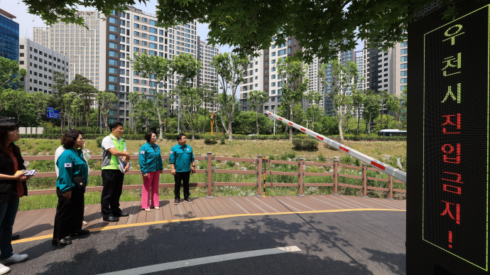 신계용 과천시장(왼쪽에서 세 번째이 양재천변 산책길 출입로에 설치된 하천 출입 통제 시스템을 점검하고 있다 사진=과천시