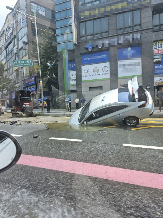 24일 오전 11시 25분께 평택 이충동의 한 도로에서 지나가던 택시가 싱크홀에 빠지는 사고가 발생했다. 사진=독자제보(김정우 님)
