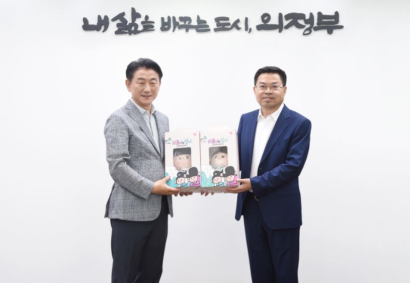 김동근 시장이 스이(史燚) 난충시 당위원회 통전부장에게 의정부시 마스코트 인형을 전달한 뒤 함께 기념사진을 찍고 있다. 사진=의정부시