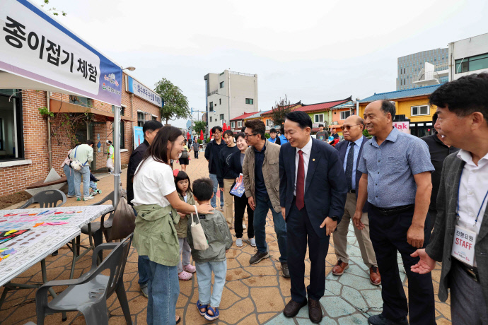 김찬진 인천 동구청장이 지난 21일 화수부두 축제 체험부스 앞에서 가족 단위 방문객과 인사를 나누고 있다. 사진=동구청