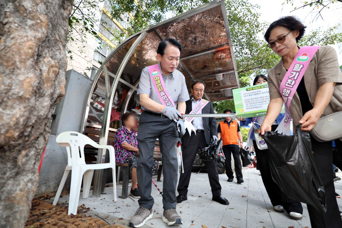 김찬진 인천 동구청장이 지난 25일 진행한 미세먼지 저감 캠페인에서 쓰레기를 줍고 있다. 사진=동구청