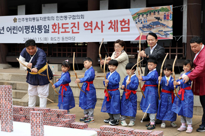 지난 15일 인천 동구 화도진공원에서 진행된 ‘어린이 평화통일 화도진 역사체험’에서 김찬진 동구청장과 아이들이 활쏘기 체험을 하고 있다. 민주평화통일자문회의 인천동구협의회가 주관한 이번 행사에는 300여 명의 아이들이 참여해 조선말 군영의 설치 배경 등을 공부했다. 사진=동구청