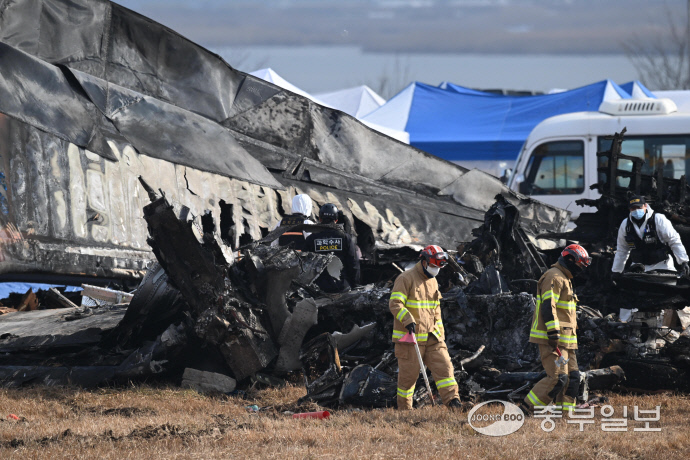 30일 오전 전남 무안국제공항에서 소방대원들이 전날 발생한 제주항공 여객기 충돌 폭발 사고 잔해를 수색하고 있다. 무안=김경민기자