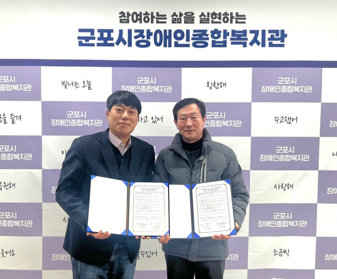 5일 유정환 군포시장애인종힙복지관장(왼쪽)과 이현희 원광대 산본병원 장례식장 사무장이 협약서를 들고 기념촬영을 하고 있다. 사진=군포시장애인종힙복지관