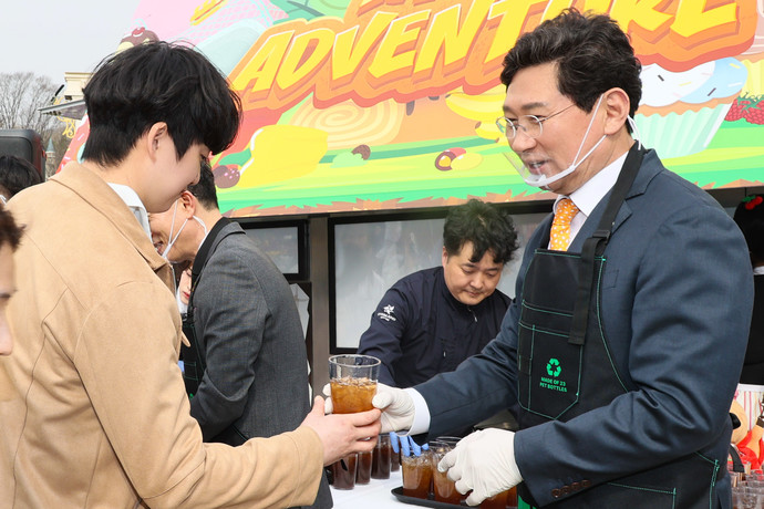 이상일 용인특례시장(오른쪽)이 25일 에버랜드에서 다회용기 사용 확대를 위한 캠페인에 참여해 시민들에게 다회용기에 담은 음료를 전달하고 있다. 사진=용인특례시청
