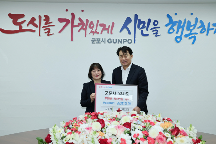 지난 22일 이영주 군포시약사회장(왼쪽)이 하은호 군포시장에게 산불 피해 복구 및 공동생활가정 지원을 위한 성금을 전달하고 기념촬영을 하고 있다. 사진=군포시청