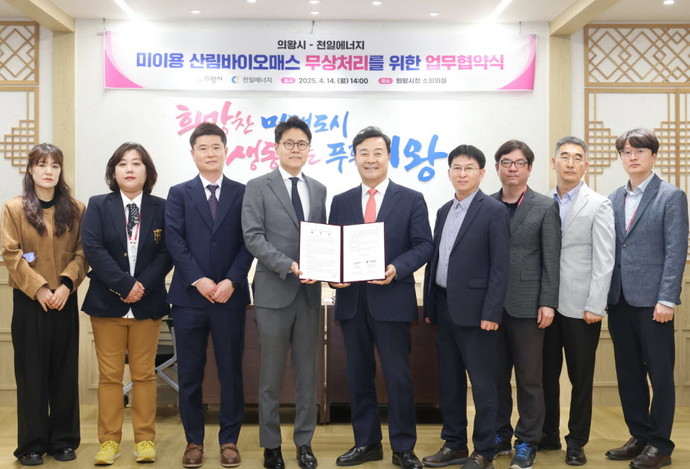 김성제 의왕시장(가운데)과 박상원 천일에너지 대표가 미이용 산림 바이오매스 무상처리 위한 업무협약을 체결하고 협약서를 들어보이고 있다. 사진=의왕시청