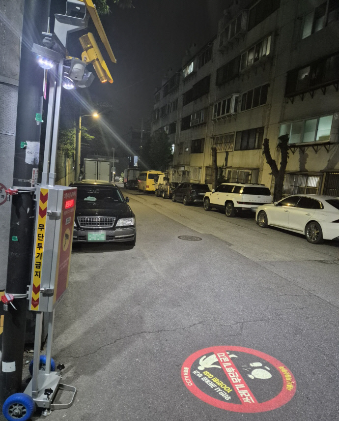 시흥 관내 주택가 골목에 설치된 이동식 감시카메라와 바닥 투사형 경고장비(로고라이트). 사진=시흥시청