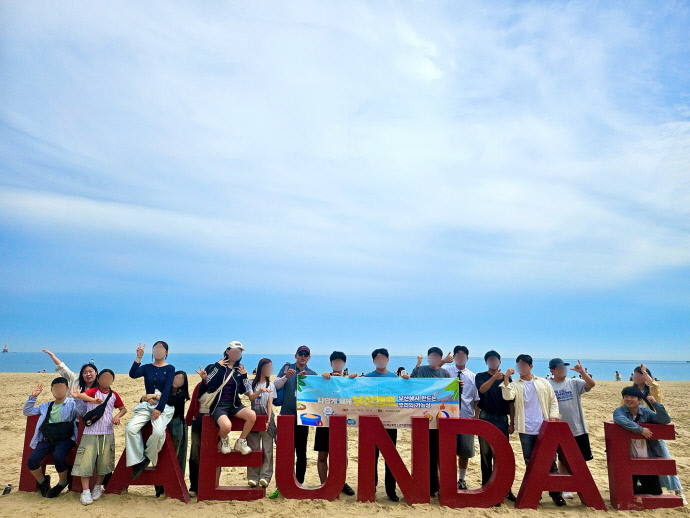 부산 해운대에서 기념촬영 중인 군포시학교밖청소년지원센터 ‘나답게, 함께’ 현장체험학습 참가자들. 사진=군포시청소년재단