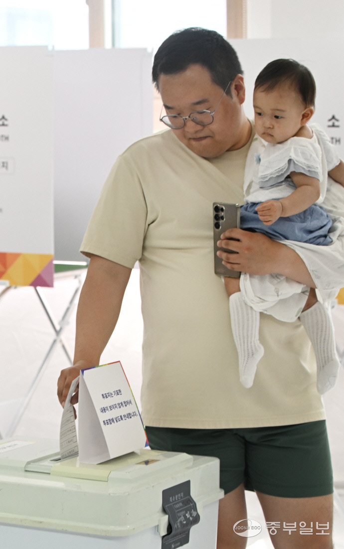 제21대 대통령선거일인 3일 오전 인천시 미추홀구 용현5동 제5투표소에서 한 유권자가 어린아이를 안고 투표하고 있다.정선식기자