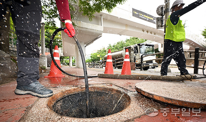 최근 장마철이 다가오며 지속적인 빗물받이와 배수관 관리가 요망되는 가운데 24일 오후 수원시 장안구 한 인도변에서 하수도 작업 관계자들이 준설장비를 동원해 배수관 내부의 오물을 제거하고 있다. 김경민기자