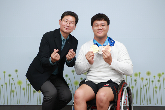 이상일 용인특례시장(왼쪽)이 1일 시장실에서 용인시 직장운동경기부 장애인수영팀 우승 메달 봉납식에서 조기성 선수를 격려한 후 기념촬영을 하고 있다. 사진=용인특례시청