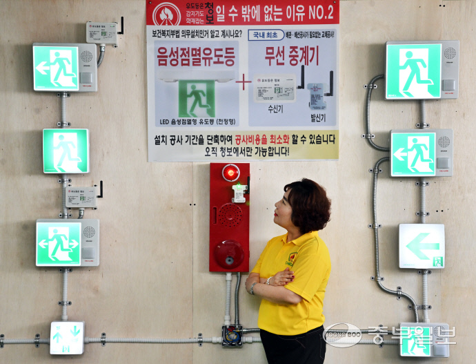 이영주 청보 대표가 청보의 음성점멸유도등 무선제어장치(왼쪽 제품)와 배선이 추가로 설치된 일반 음성점멸유도등의 차이점을 설명하고 있다. 김경민기자