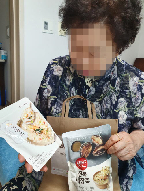 의왕시 사랑채노인복지관이 전달한 영양죽 세트를 살펴보는 어르신의 모습. 사진=의왕시청