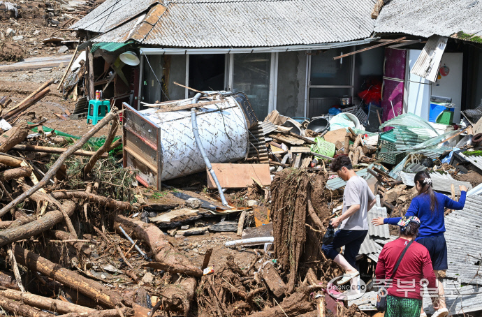 밤사이 내린 폭우로 가평군 신상3리 마을회관 인근에서 산사태가 발생한 가운데 20일 오후 피해지역 주민들이 토사로 덮인 주택으로 향하고 있다. 임채운기자