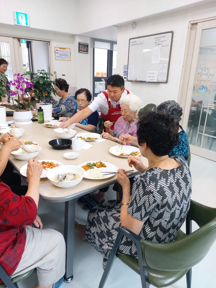 박세광 본오1동장이 30일 정곡경로당에서 어른신들께 삼계탕을 배식하고 있다. 사진=정곡경로당