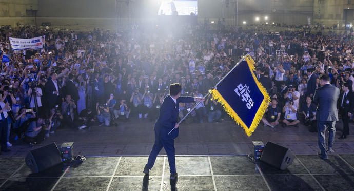 더불어민주당 정청래 신임 당대표가 2일 고양 킨텍스에서 열린 전국당원대회에서 김병기 당대표 직무대행 겸 원내대표로부터 받은 당기를 흔들고 있다. 연합뉴스