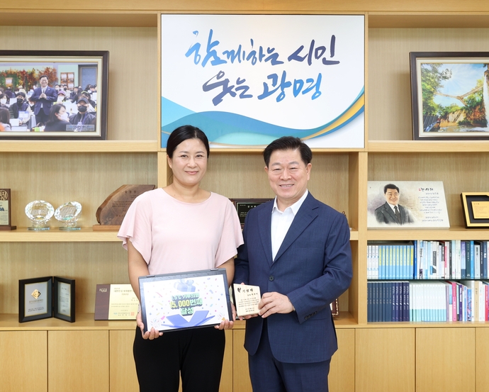 박승원 광명시장(오른쪽)이  21일 오전 시장실에서 1만5천번째 기후의병 최 모씨(왼쪽)에게 기념패를 전달하고 있다.    사진=광명시청