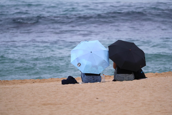 12일 강원 강릉시 강문해변에서 시민들이 우산을 쓰고 바다를 바라보고 있다.  사진=연합뉴스