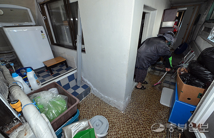 고령층들이 금전적 부담으로 반지하와 쪽방촌 등 취약한 주거환경으로 내몰리고 있는 가운데 15일 오전 수원시 권선구 소재 반지하촌에서 주민이 비로 인해 고여 있는 물을 빼내고 있다. 임채운기자