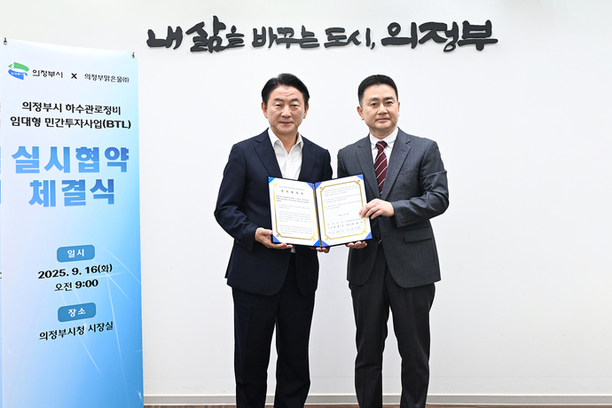 김동근 의정부시장(왼쪽)이 지난 16일 김명구 의정부맑은물주식회사 대표이사와 하수관로정비사업 실시 협약을 체결한 뒤 협약서를 들어보이고 있다. 사진=의정부시청