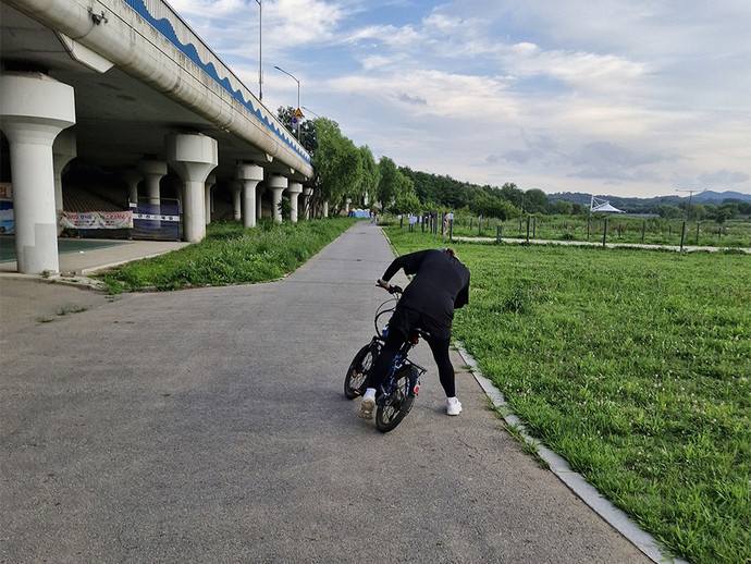 성남시에 위치한 사회적협동조합 일하는학교와 중부일보의 협업 프로그램 ‘모멘텀’에 참여하는 청년이 성남시 탄천 일대에서 자전거를 타고 있다. 사진=일하는학교