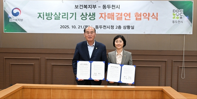 박형덕 동두천시장(왼쪽)과 이스란 보건복지부 제1차관이 지난 21일 동두천시청 상황실에서 ‘지방살리기 상생 자매결연 협약서’를 교환하며 기념촬영을 하고 있다. 사진=동두천시청