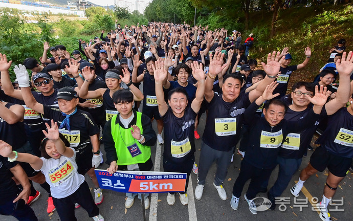 25일 의정부에서 열린 ‘2025 의정부시 하천 마라톤 전국대회’에서 김동근 의정부시장과 김연균 의정부시의장 등 참가자들이 단체로 손을 들어보이고 있다. 사진=임채운 기자