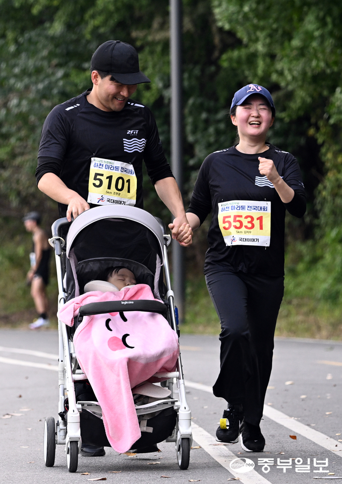 마라톤에 참가한 가족들이 손을 잡고 결승선을 통과하고 있다. 임채운기자