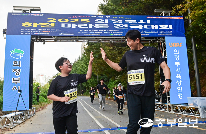 마라톤 참가자들이 결승선을 통과하며 하이파이브를 하고 있다. 임채운기자
