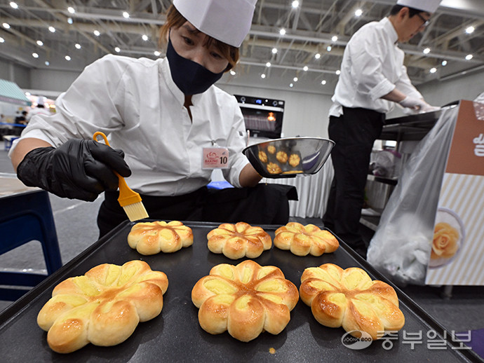 경기도 주최, ㈔도농문화콘텐츠연구회 주관으로 수원컨벤션센터 1·2 전시장에서 개최된 경기미 디저트 페스타에서 한 콘테스트 참가자가 잘 구워진 빵을 오븐에서 꺼내 버터를 바르고 있다. 김경민기자
