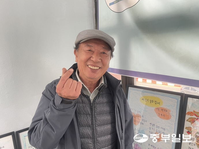 이웅기 의왕시민학교 교장이 교내 전시된 문해교육 작품 앞에서 환하게 미소 짓고 있다. 손용현기자