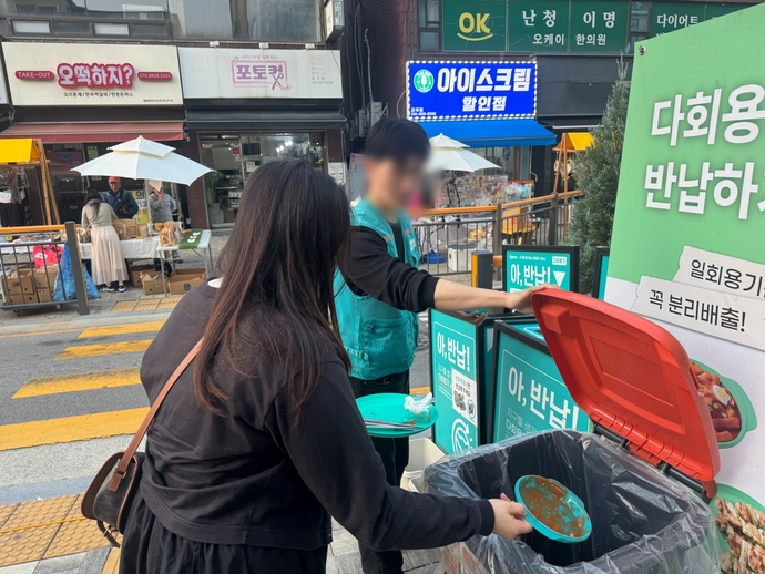 남양주시가 다회용기 지원 사업을 펼치고 있는 가운데 한 시민이 다회용기 반납함에 음식을 담았던 그릇을 반납하고 있다. 사진=남양주시