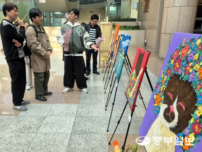 10일 수원시청사 본관 1층에서 열린 ‘새빛드림 일자리센터 제1회 미술전시회’에 참여한 작가가 자신의 작품을 설명하고 있다. 강현수기자