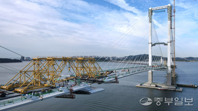 지난 12일 인천시 중구 영종하늘도시와 서구 청라국제도시와를 잇는 제3연륙교 사장교 구간에서 대형 크레인이 마지막 상판을 들어 올려 주탑과 연결하는 작업이 진행되고 있다. 이날 최종 연결은 수개월간 이어진 정밀 시공 끝에 이뤄진 것으로, 제3연륙교가 본격적인 완성 단계에 접어들었음을 알리는 상징적인 순간이 됐다.정선식기자