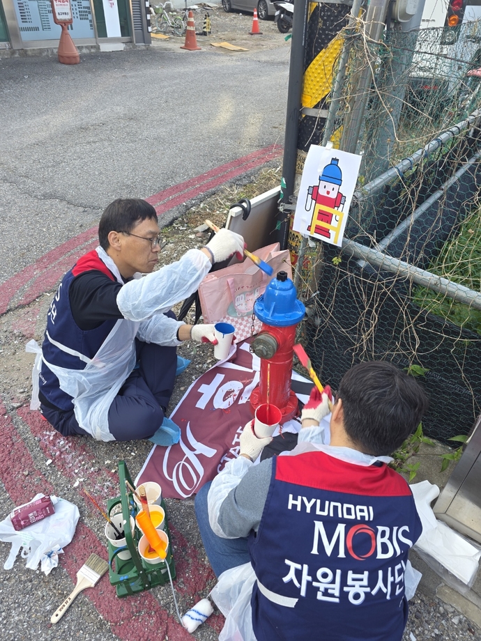 용인서부소방서와 함께 7일 ‘지상식 소화전 도색 봉사활동’에 나선 현대모비스 안전지킴이 참가자들이 소화전을 도색하고 있다. 사진=용인서부소방서