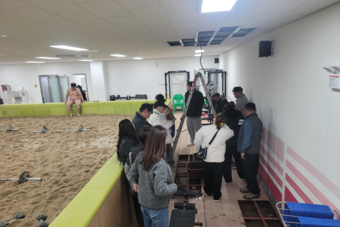 10일 오후 광주중 씨름훈련장에서 누수를 잡지 못해 보수 공사가 중단된 현장을 학부모들이 지켜보고 있다. 사진=광주중학교